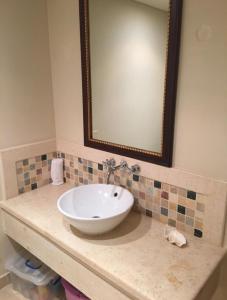 bagno con lavandino e specchio su un bancone di Marina residence Chalet port ghalib a Port Ghalib