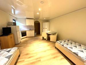 Una pequeña habitación con dos camas y una cocina. en Hudolin-Vermietungen, en Gundelsheim