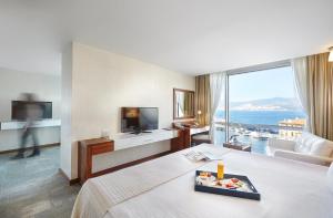 a hotel room with a bed and a view of the ocean at Kordon Hotel Pasaport in İzmir