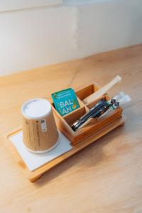 a wooden tray with pens and a cup on a table at Kyriad Cannes - Mandelieu in Cannes