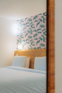 a reflection of a bedroom with a bed and a wall at Kyriad Cannes - Mandelieu in Cannes