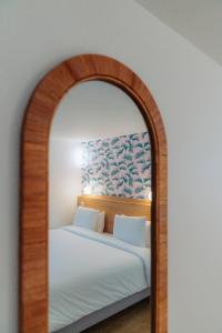 a bedroom with a mirror with a bed in it at Kyriad Cannes - Mandelieu in Cannes