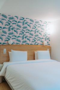 a bedroom with a bed with a blue and white wallpaper at Kyriad Cannes - Mandelieu in Cannes