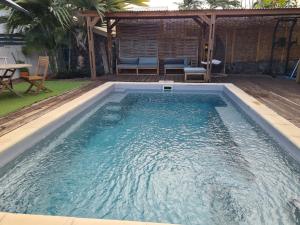 una piscina en un patio trasero con mesa y sillas en Ti coin tranquille, en Étang-Salé 5 fotos más