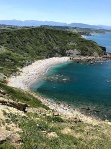 a beach on a hill with a body of water at Apto vacacional en Barrica in Barrika