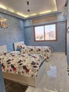 a bedroom with two beds and a window at Jardin Majorel Appartement en résidence fermée in Marrakech
