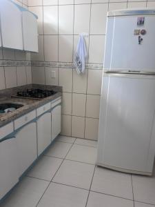 a white kitchen with a refrigerator and a sink at Recanto dos pássaros in Penha