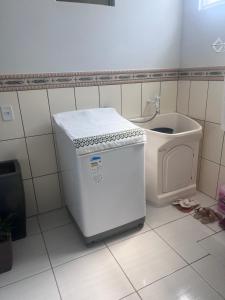 a small refrigerator in a bathroom next to a toilet at Recanto dos pássaros in Penha