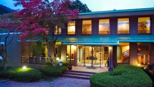 een huis met een boom ervoor bij Sengokuhara Onsen Hotel in Hakone