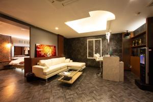 a living room with a white couch and a bed at ホテルベルファス in Koriyama
