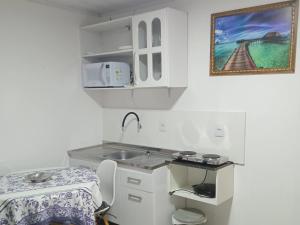 una piccola cucina con un lavello e un tavolo di Aluguel casa azul a Capão da Canoa