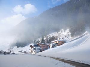 pokryta śniegiem góra z domami i stokiem narciarskim w obiekcie Sun Alpin w mieście Ischgl