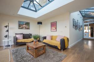 a living room with two couches and a table at Charming Victorian House w Parking River Walks - Pass the Keys in Windsor
