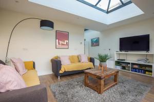 a living room with two couches and a tv at Charming Victorian House w Parking River Walks - Pass the Keys in Windsor