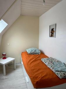 a small bedroom with a bed and a table at Petite maison sur ferme 5min de la plage idéal professionnel in Trémel