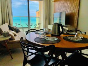a dining room with a table with a view of the ocean at Praia de Itaparica - Frente mar! Totalmente Montado! Até 5 hóspedes in Vila Velha