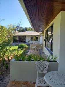a patio with a table and chairs and a house at Somer House Guest Suites in Somerset West
