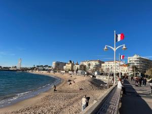 a beach with people and the ocean and buildings at Appartement et Balcon Entier 4 personnes climatisé plage a 100 m in Saint-Raphaël