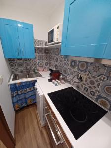 a kitchen with blue cabinets and a stove top oven at Zula House - Apartment Lake view in Bellano