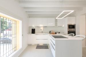 a kitchen with white cabinets and a large window at The White House - business and charme in Padova