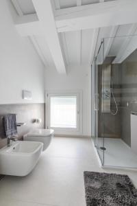 a white bathroom with two sinks and a shower at The White House - business and charme in Padova +26 photos