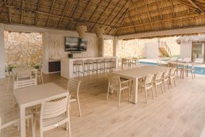 a dining room with tables and chairs and a tv at Exclusivo Departamento con vista a la marina in Conchal