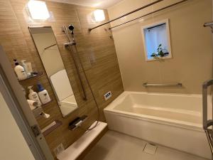 a bathroom with a shower and a tub and a sink at HomeStay 輝き Kagayaki ホスト在宅タイプ 一日一組限定 in Matsudo +22 photos