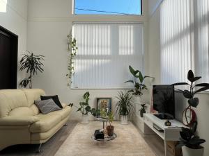 a living room with a couch and potted plants at HomeStay 輝き Kagayaki ホスト在宅タイプ 一日一組限定 in Matsudo