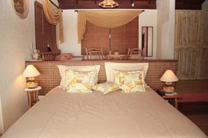 1 dormitorio con 1 cama grande con almohadas en Bangalore Suites, en Garopaba