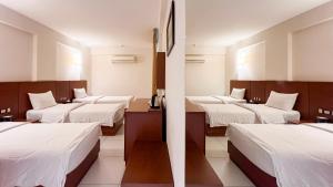 a row of beds in a room with white sheets at Coral Karbala Hotel in Karbala +53 photos