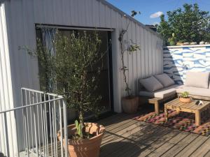 a patio with a couch and a table on a deck at La Canopée in Bordeaux