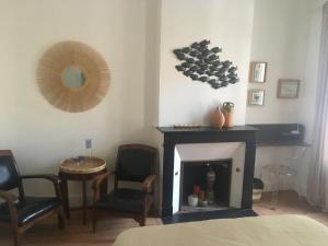 a living room with a fireplace and a mirror at La Canopée in Bordeaux