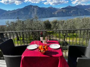 a table with a red table cloth and a bowl of fruit at Villalvento in Brenzone sul Garda