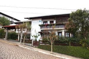 Hospedaria Gãstehaus Enzian في تريز تيلياس: مبنى بصناديق الزهور على جانب شارع