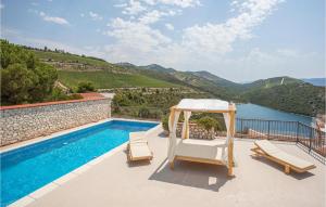 a swimming pool with two chairs and a gazebo at Holiday Home Kremena 72 With Outdoor Swimmingpool in Klek