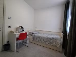 a bedroom with a bed and a desk with a computer at BB Cadore casa vacanze in Varese