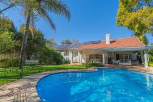a swimming pool in front of a house at The Manor at Chaplin Manor in Johannesburg