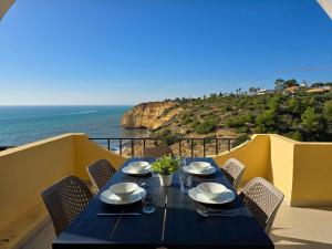 a table on a balcony with a view of the ocean at GOLDEN SUN - Sunny Balcony, Sea View, Beach, AC in Carvoeiro