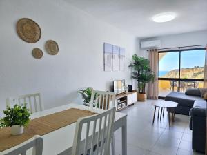 a living room with a table and chairs and a couch at GOLDEN SUN - Sunny Balcony, Sea View, Beach, AC in Carvoeiro