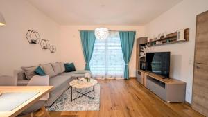 a living room with a couch and a tv at InnBlue Apartment in Braunau am Inn