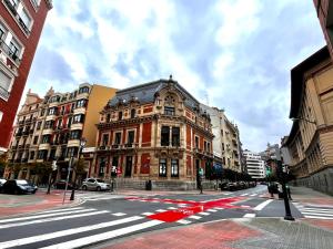 skrzyżowanie ulicy miejskiej z budynkiem w obiekcie Piso en el centro de Bilbao, frente a la Alhóndiga w mieście Bilbao