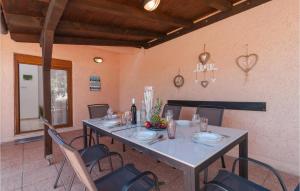 a dining room with a long table and chairs at Cozy Home In Vrbanj With Sauna in Basina