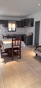 a kitchen and dining room with a table and chairs at Apart Las Hermanas in Colón