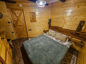 a bedroom with a bed and a wooden wall at Kuća za odmor Štefi in Donji Koncovčak