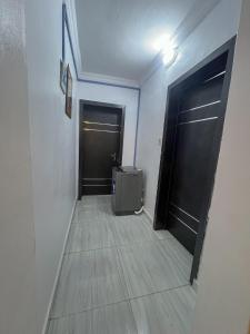 a hallway with two black doors and a suitcase at Memento Courts in Lagos