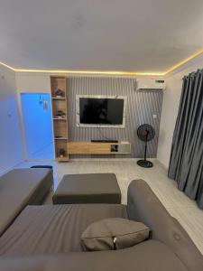 a living room with a couch and a flat screen tv at Memento Courts in Lagos