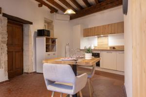 a kitchen with a wooden table and chairs at Le Nostradamus - Hypercentre - Clim - Wifi in Saint-Rémy-de-Provence +13 photos