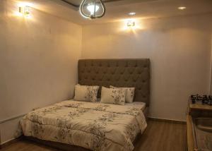 a bedroom with a bed with a headboard and two pillows at Memento Courts in Lagos