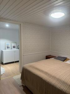 a bedroom with a bed and a light on the ceiling at Upea Villa Solliden, 3mh, poreallas ja p-paikkoja in Espoo