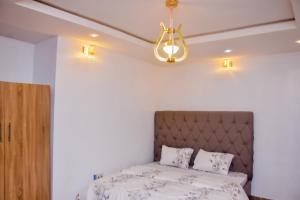 a bedroom with a bed and a chandelier at Memento Courts in Lagos